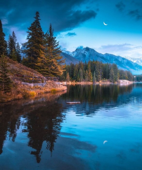 Twilight shot of mountains behind a lake as an example of beautiful landscape photography