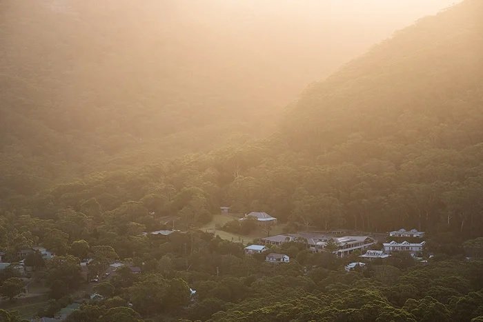 Hazy edited landscape photo of a village on a woodland hillside