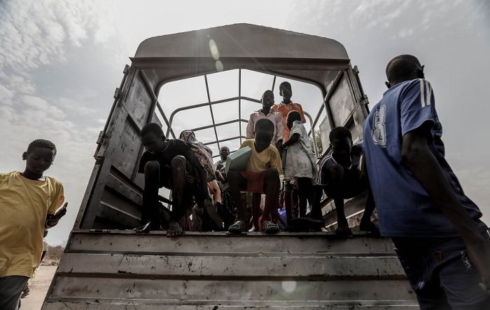 在非洲，孩子们从卡车后面走下来，作为纪实摄影的一个例子