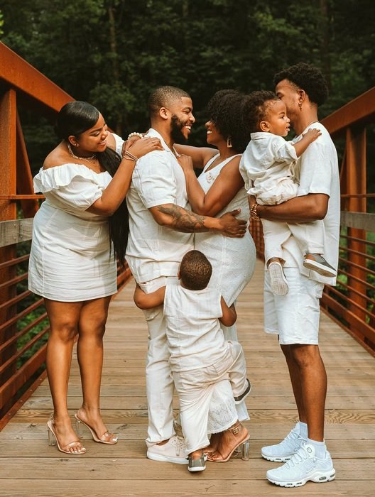 一家人在桥上穿着一身白衣，拍家庭照