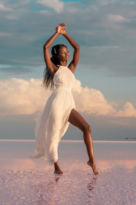 Fashion photography shot of Woman in white dress standing on salt flats