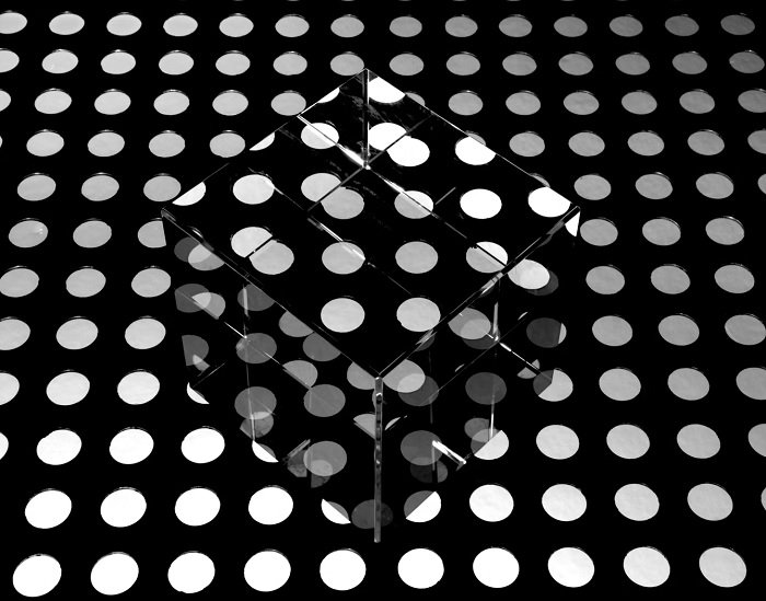 玻璃立方在黑白相间的点缀地板上，作为美术摄影的范例