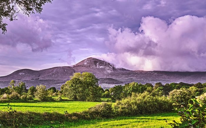High Dynamic range landscape photo of a mountain behind a field