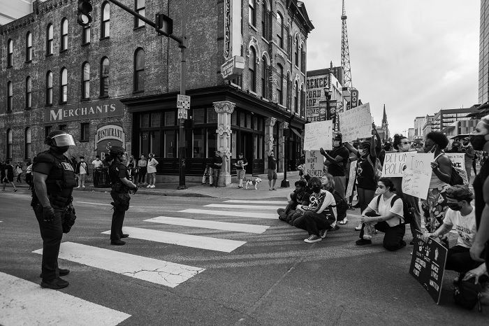 Protesters in front of police in the street captured by a photojournalist