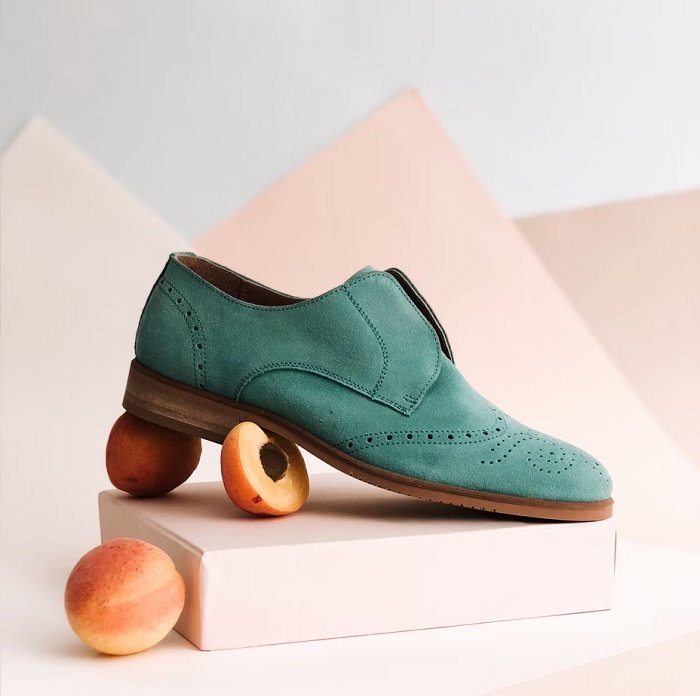Product photo of a green shoe with a peach beneath it
