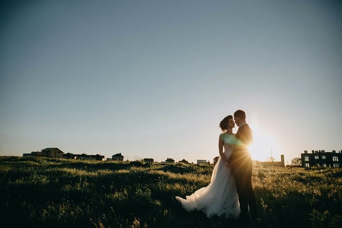 新娘和新郎在野外的日落照作为婚礼摄影的一个例子