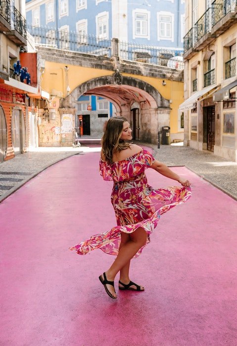 Woman dancing in a dress on a colorful urban street