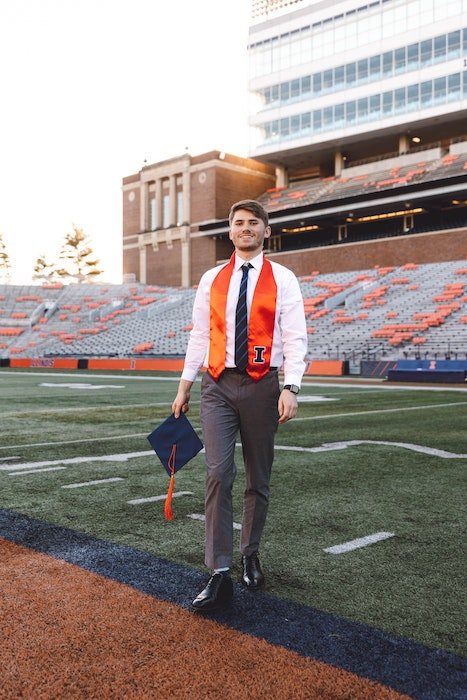 Senior high-school graduate posing on a sports field for a senior photoshoot