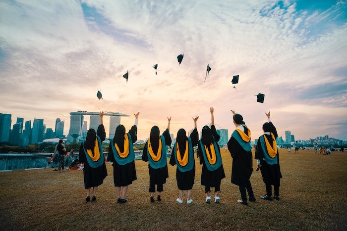 Cool senior picture idea of senior high-school graduates tossing their graduation caps in the air