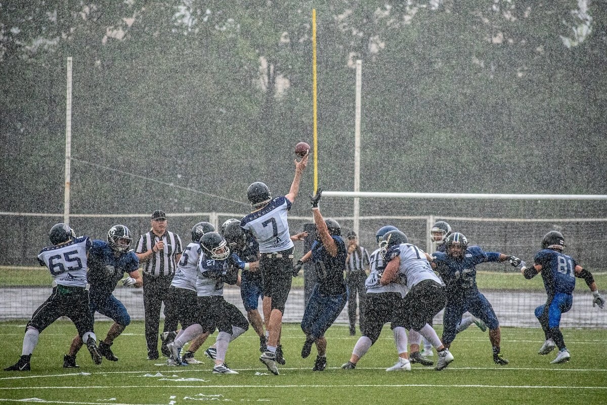 Football players playing in the rain to show sports photography settings