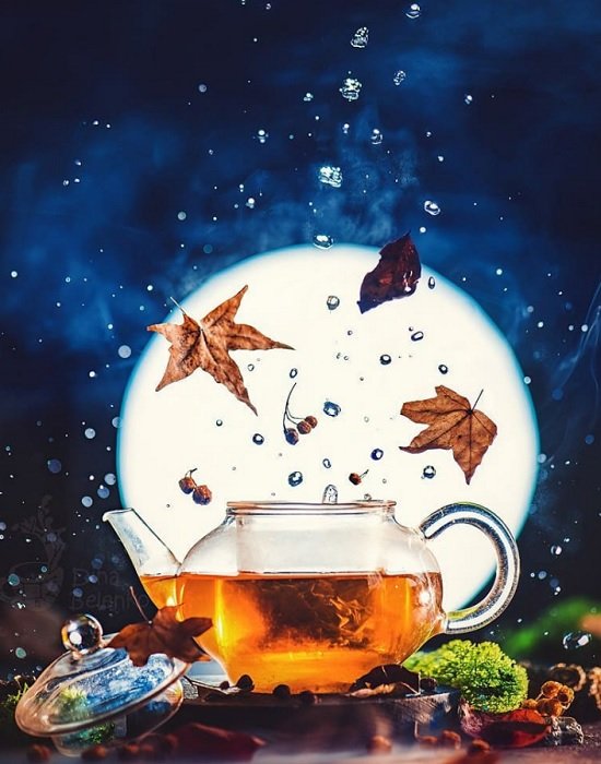 Filled teapot with leaves and water droplets falling against a full moon nighttime background