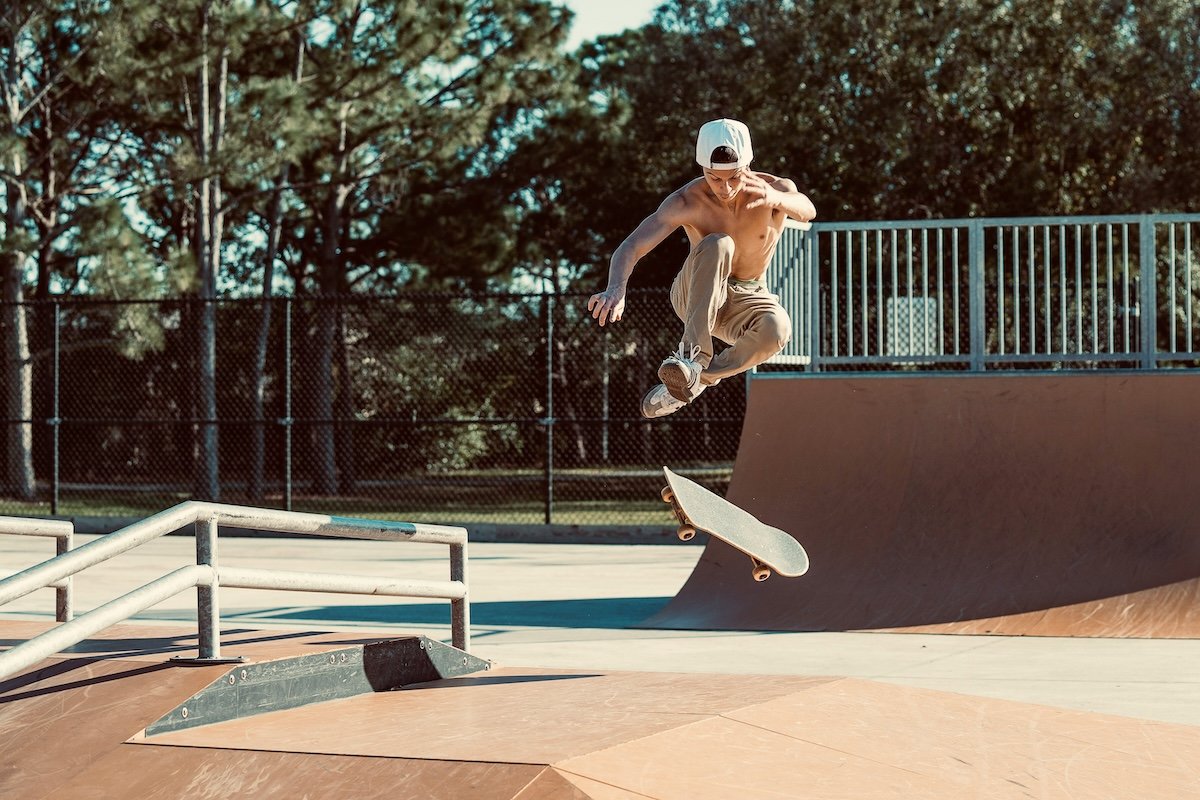 A skateboarder doing a trick in a skate park shot with an f/4.0 aperture