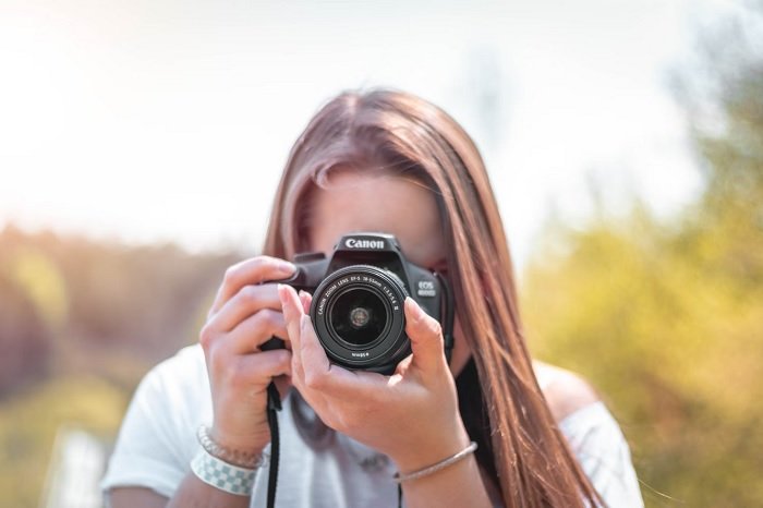 Girl taking a picture with a canon camera