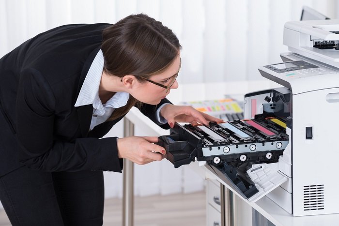 Woman reloading cartridges in a printer with automatic document feeder