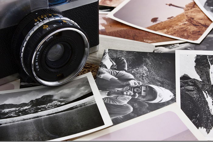 Premium Photo  Case with old black and white photographs film camera and film  reel old photos on foreground