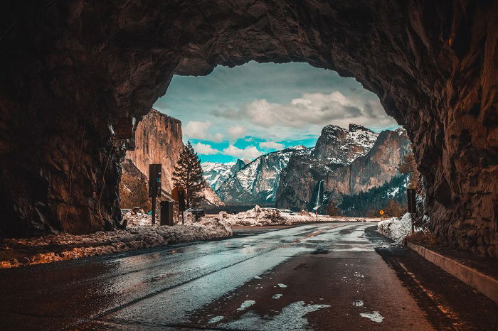 View looking out of a tunnel onto a mountain range