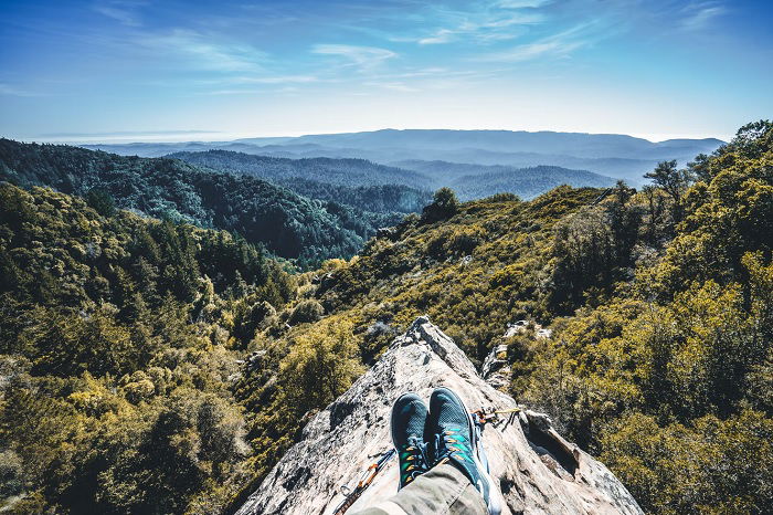 POV of a person sitting on top of a rocky mountain top