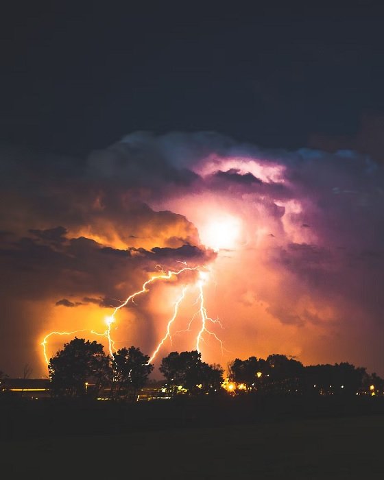 Lightning striking over a village at night