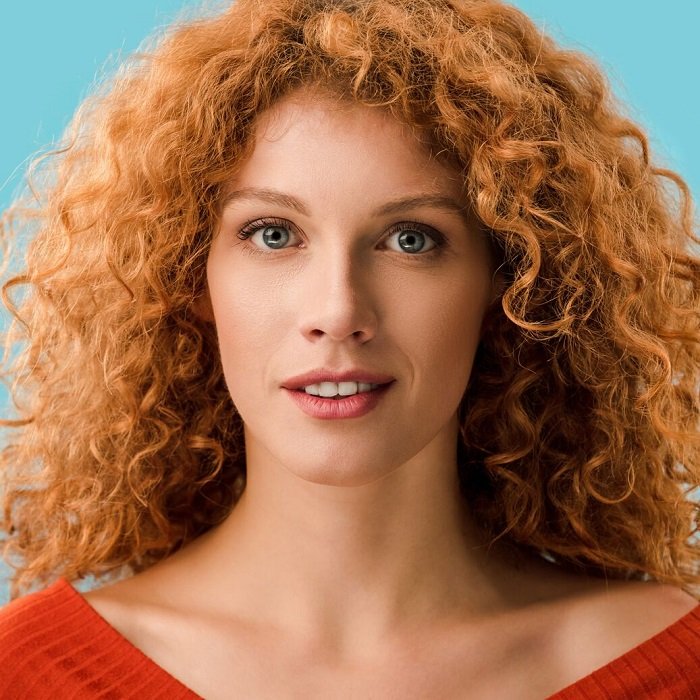 Close portrait of a woman with curly red hair
