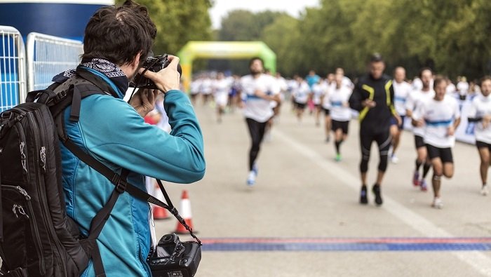 Photographer shooting a marathon from the sidelines