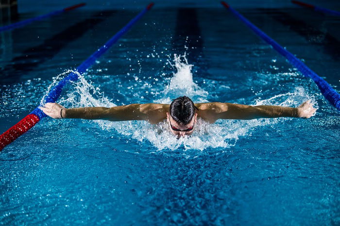 Swimmer performing the butterfly stroke in a professional swimming pool