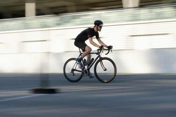 Cyclist in black riding quickly