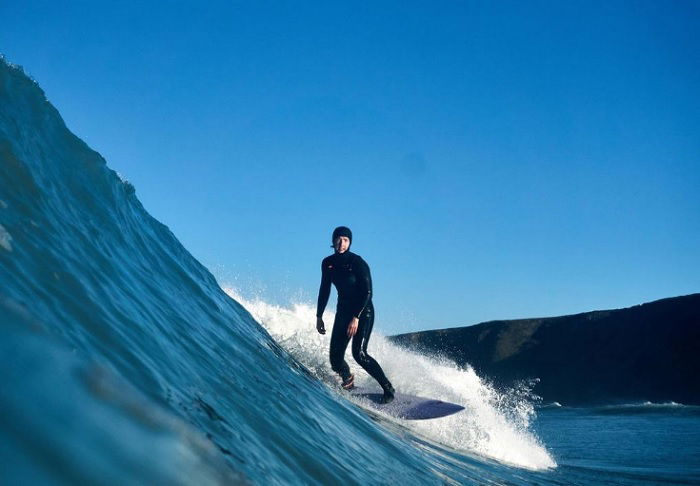 Surfer standing on a surfboard riding a wave