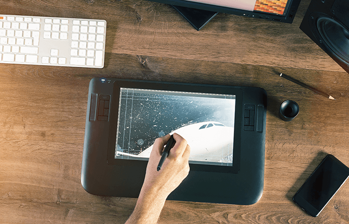 A person working on a plane graphic on a display drawing tablet