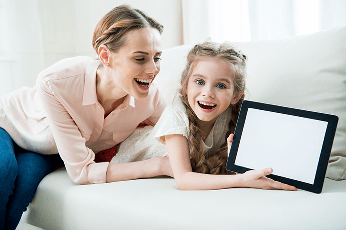 Woman and young girl showing a tablet computer