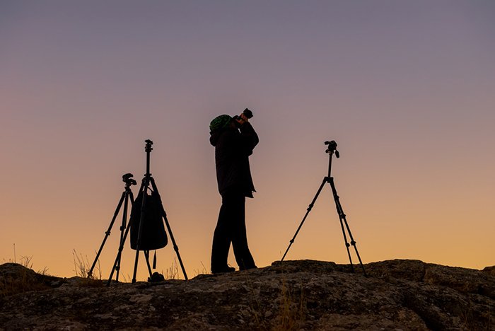 Photographer three tripods sunset silhouette