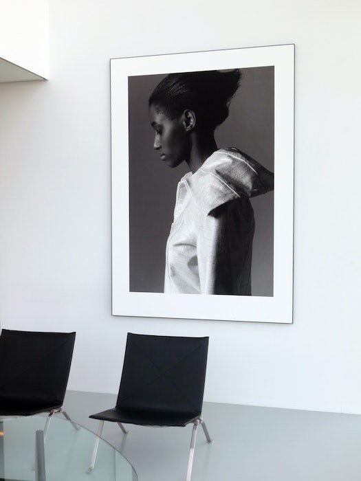 Grande impressão em preto e branco do retrato de uma mulher pendurado na parede.