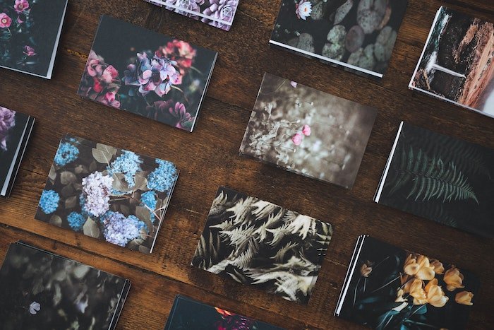 Flat lay of lustre & glossy nature photo prints neatly stacked and arranged on a table