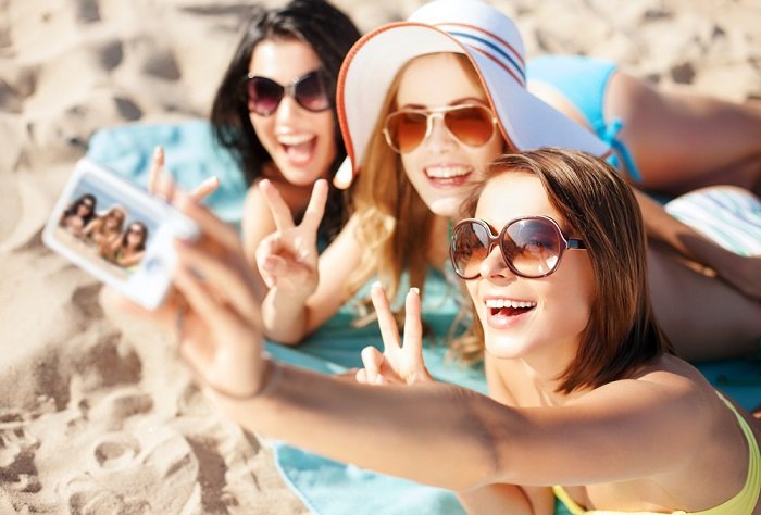 Three girls on a beach taking a selfie