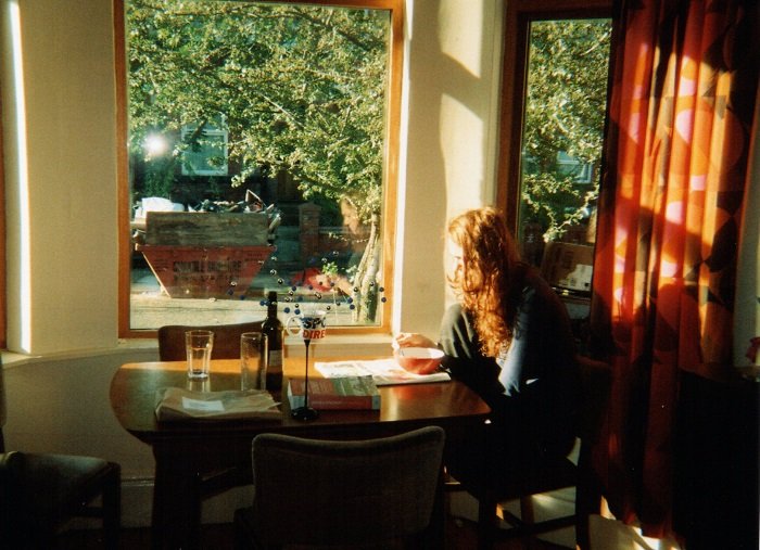Woman sitting next to a window with sunlight coming through
