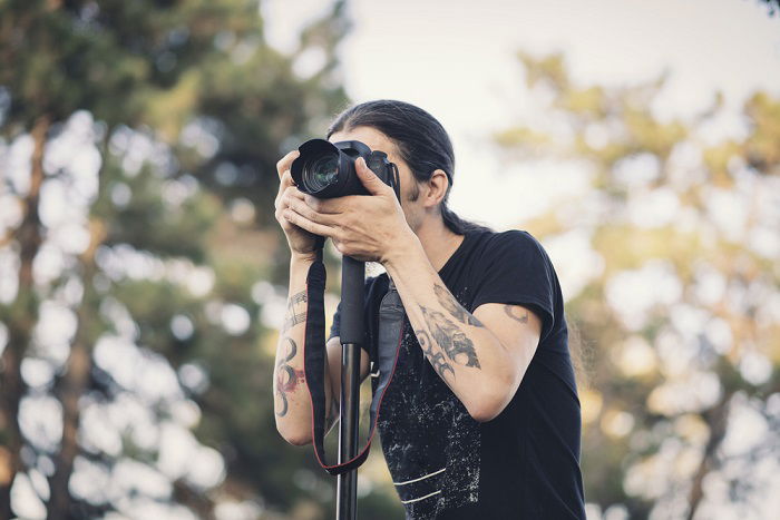 Woman taking a photo with a camera on a monopod