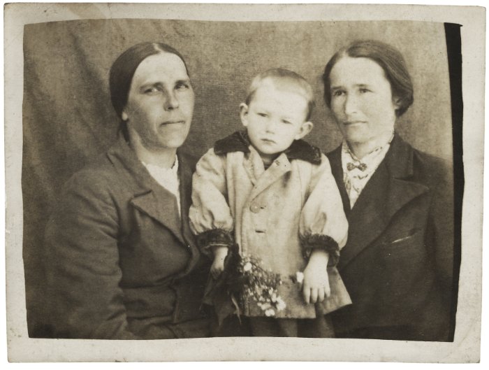 Antique photo of two women and a child posing while sitting