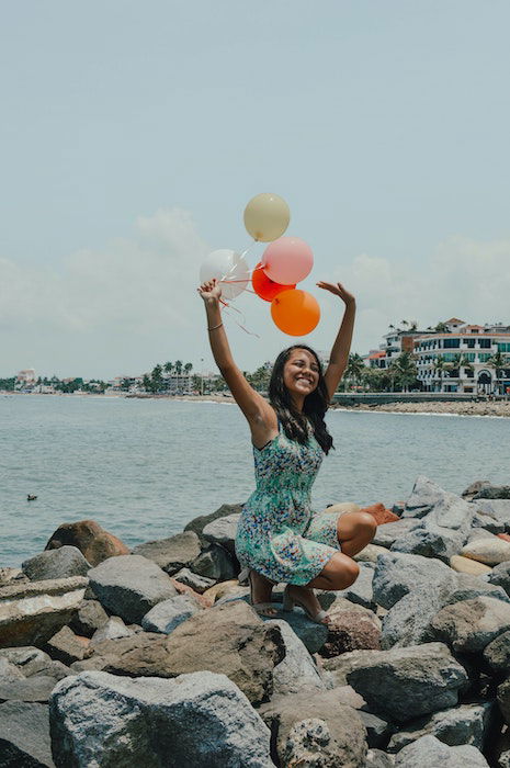 Beautiful brunette Asian girl enjoys birthday celebration poses with tasty  cake being on festive par Stock Photo by wayhomestudioo