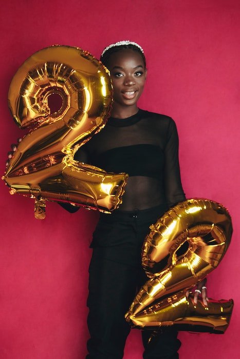 girl posing with numbered balloons as a birthday photoshoot idea