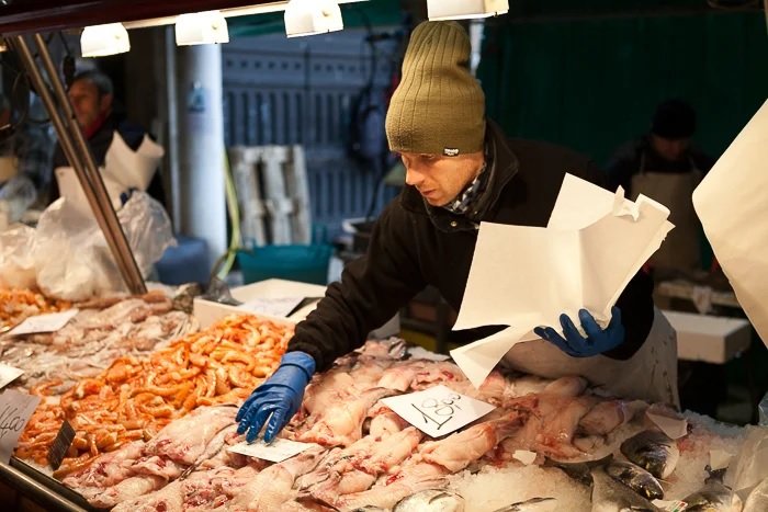一名男子在海鲜市场上调整贝类