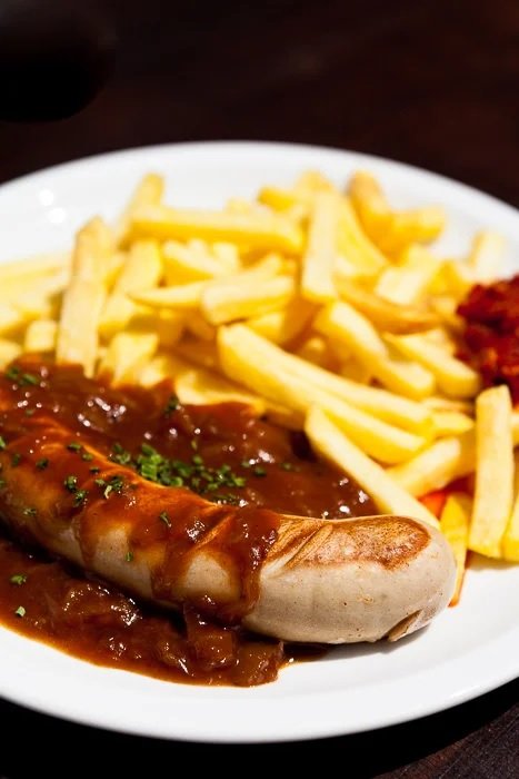close up of sausage, chips, and gravy on a plate