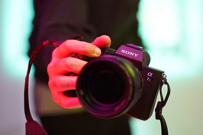 A hand holding a Sony A7 III