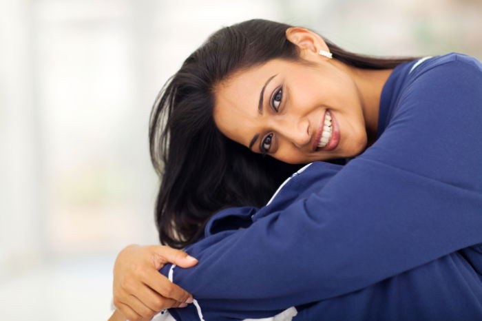 A woman resting her head on her knees as an example of a sitting pose