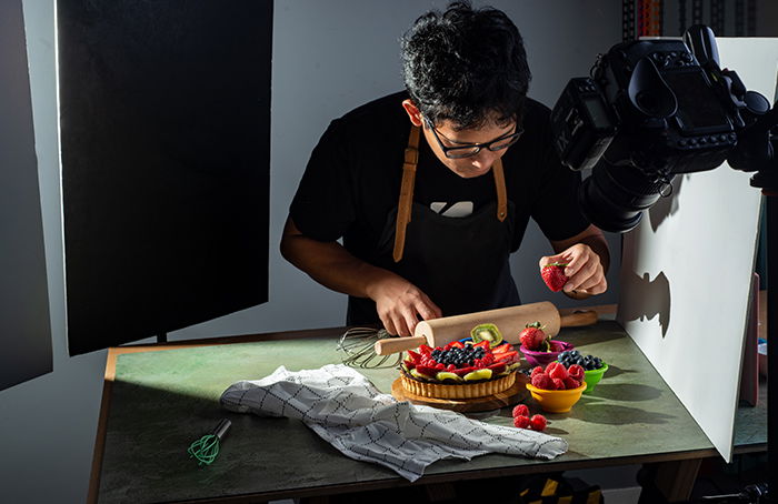 Um fotógrafo projetando uma torta de frutas.