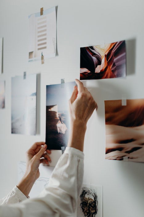 Person sticking prints onto a wall 