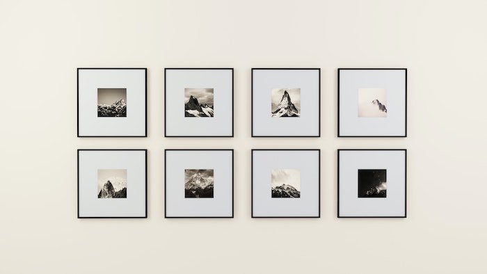 8 black and white prints hanging symmetrically on a wall 