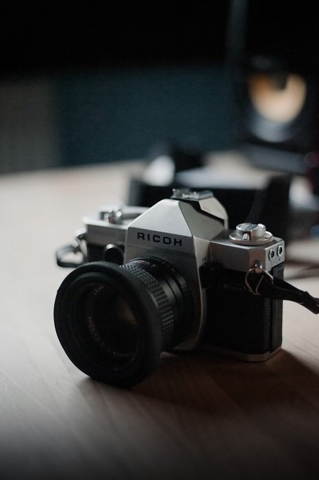 Ricoh SLR camera on a table in a dimly lit room