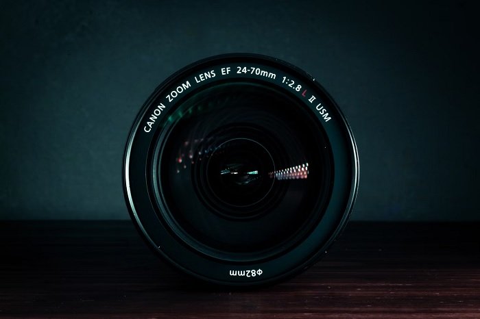 Canon USM lens on a table against a black backdrop