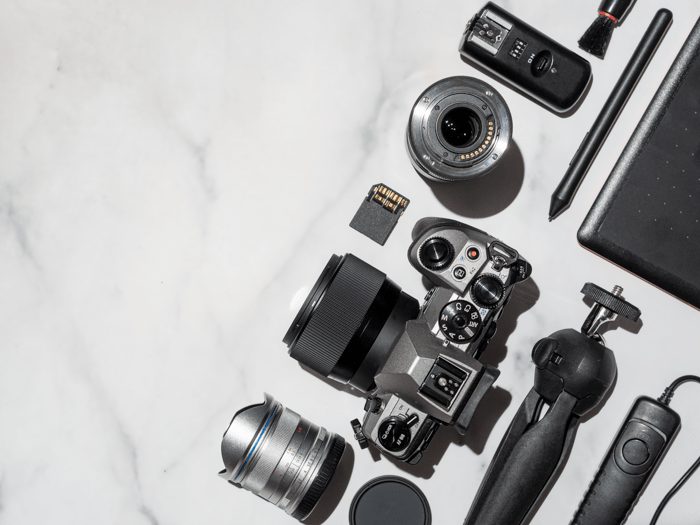 A knolling shot of camera surrounded by camera accessories