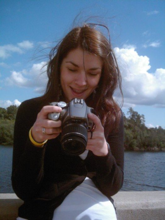 Teenage girl looking down at her camera and smiling