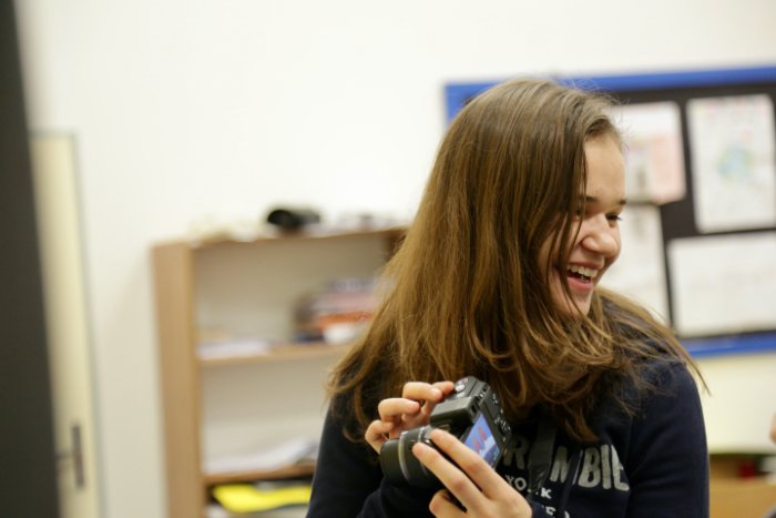 Teenage girl smiling and showing someone their camera